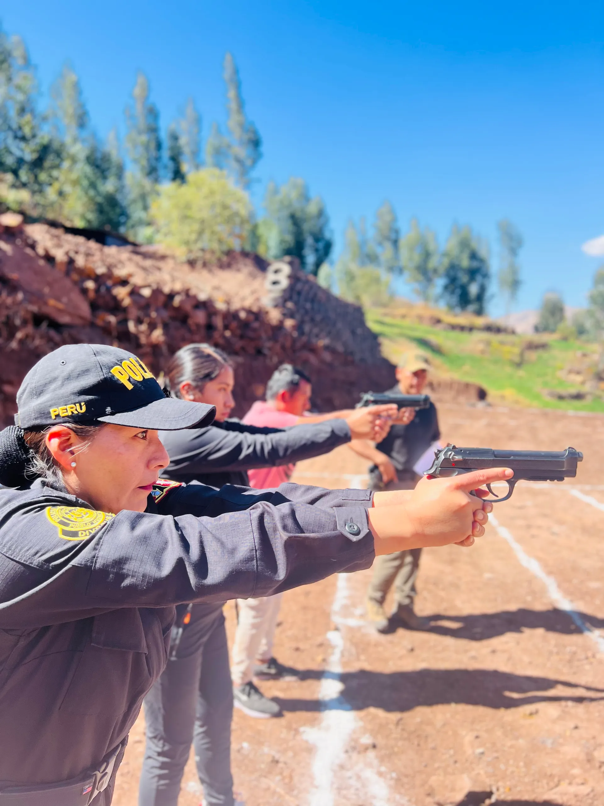 Efectivos de la PNP y participantes civiles en la línea de tiro de un polígono en Cusco